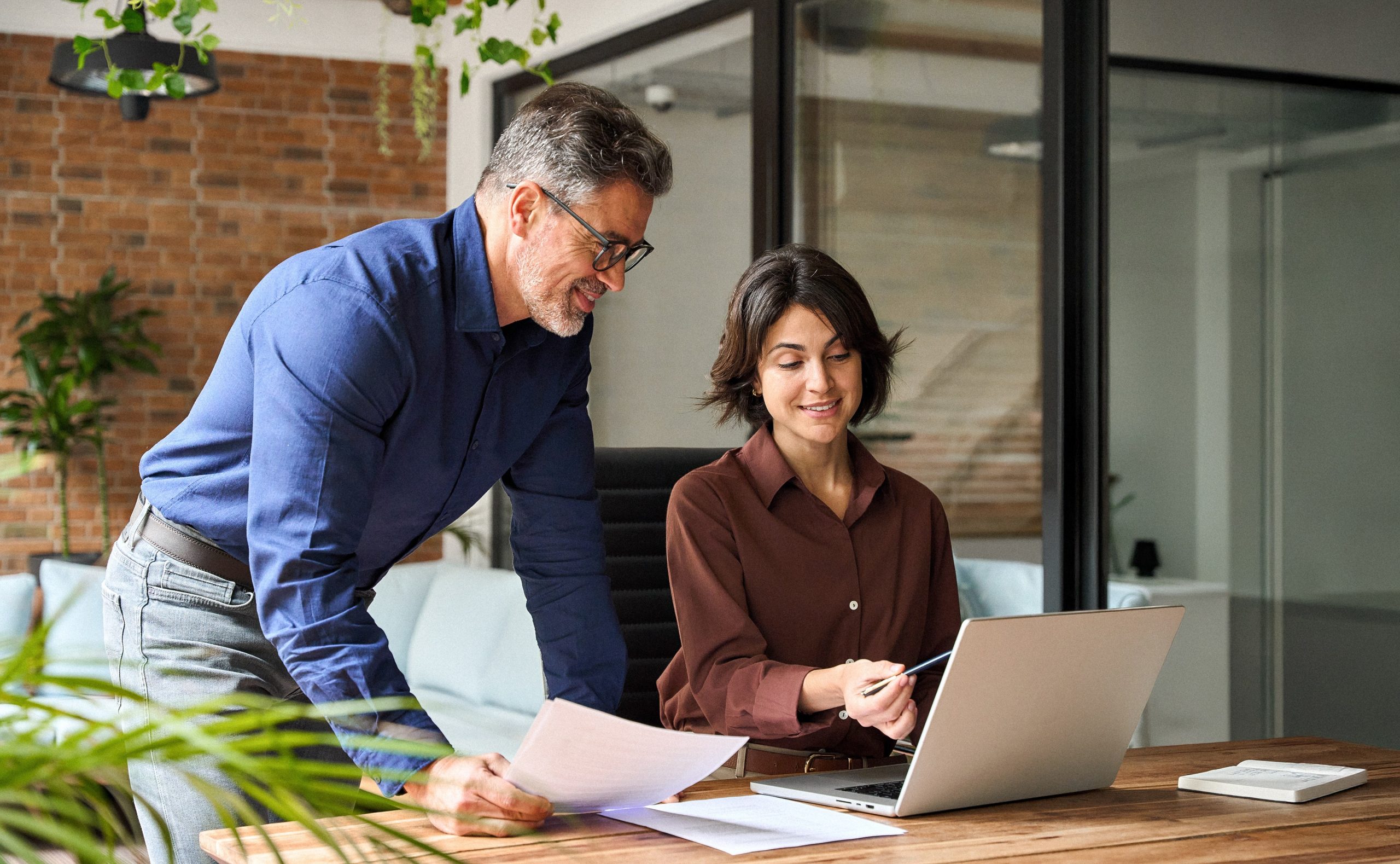 Two happy busy business leaders man and woman working in office using laptop.